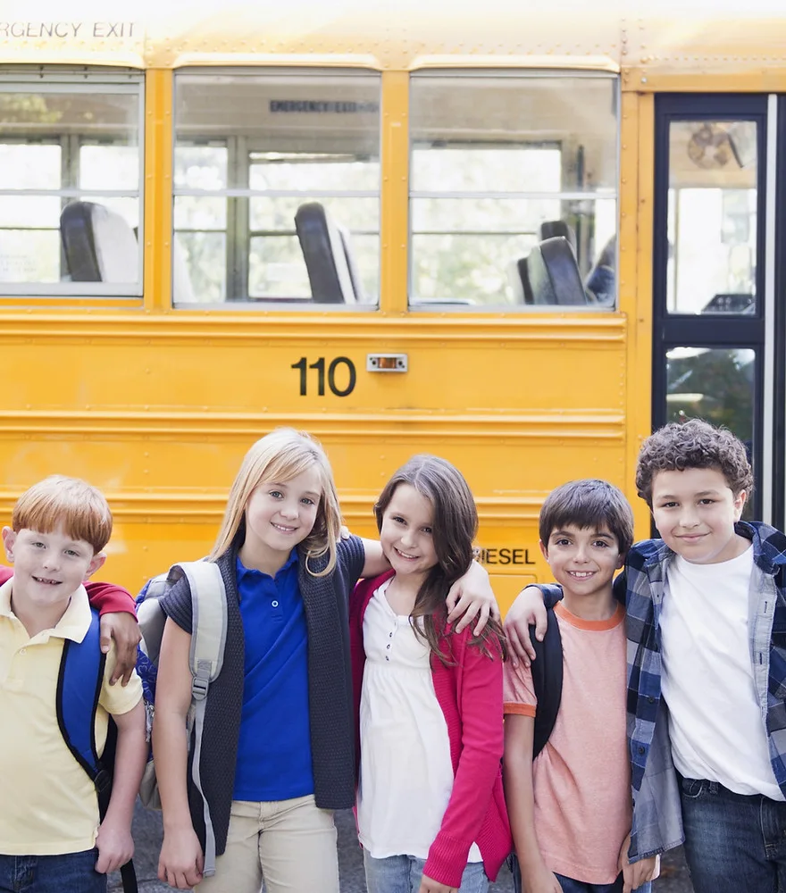 Children next to a yellow school bus in Canada